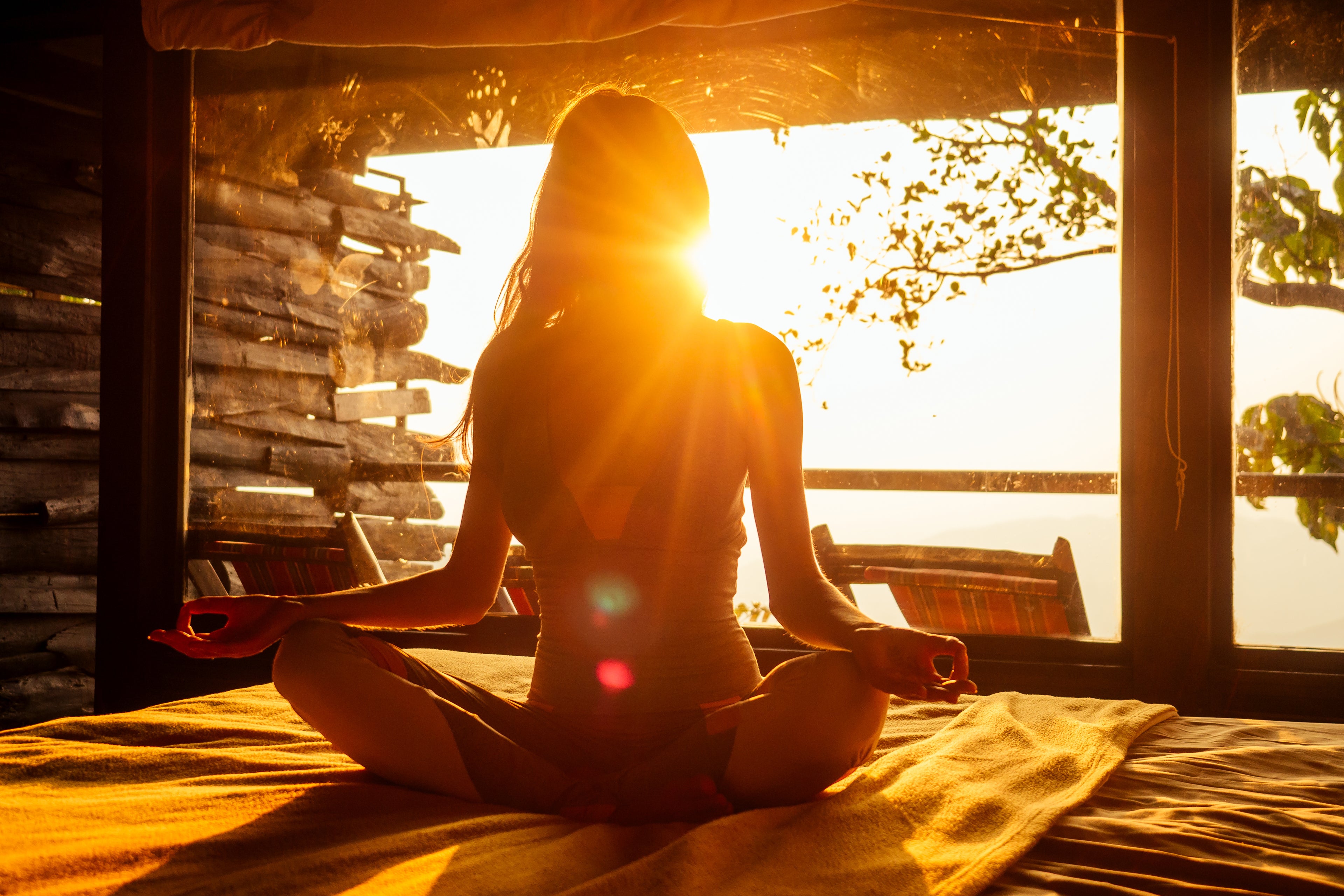 Art of Vedas Ayurveda Journey - Woman Meditating in Lotus Pose at Sunset for Holistic Ayurvedic Wellness and Spiritual Balance