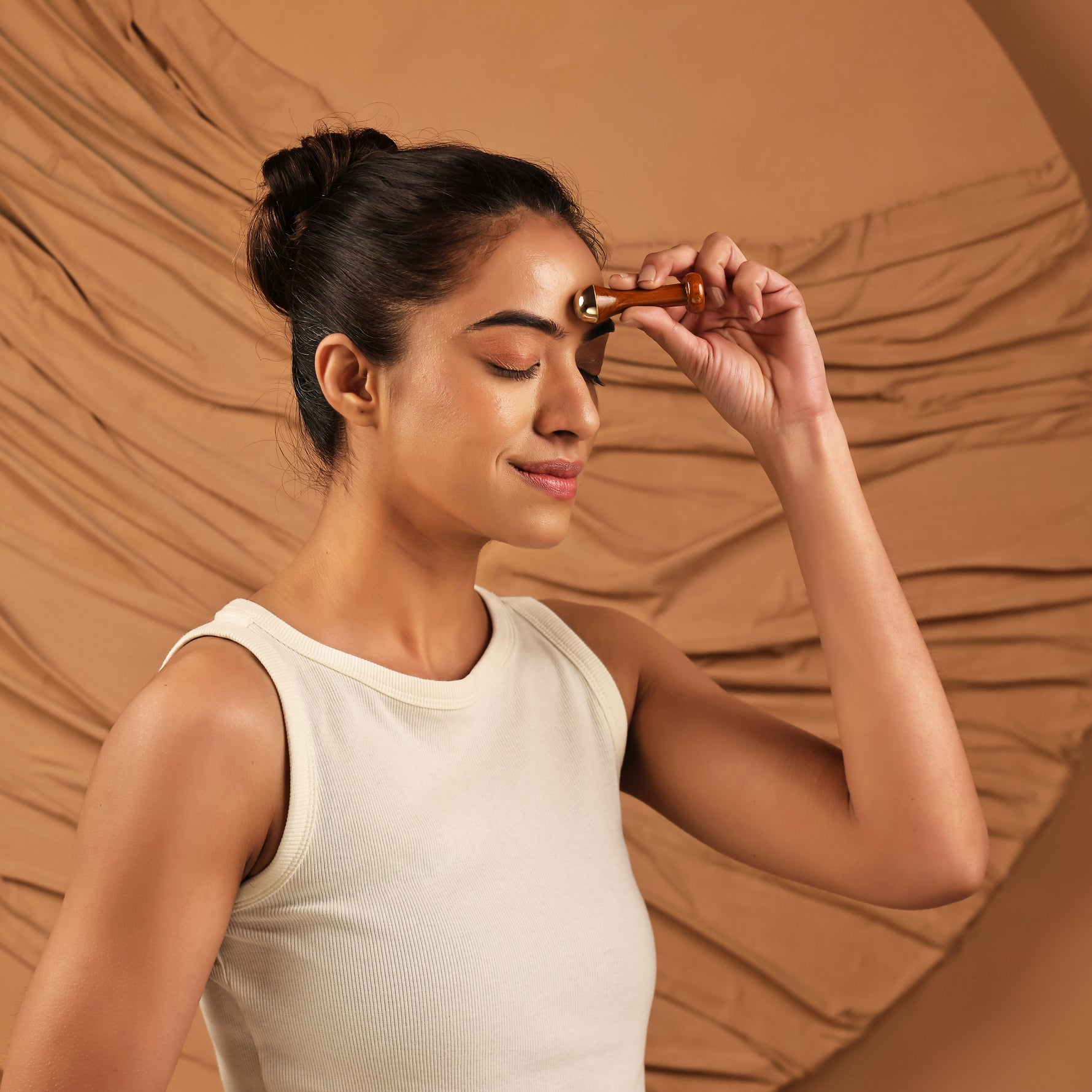 Art of Vedas Kansa Marma Massage Wand - Woman Applying Kansa Wand to Third Eye Marma Point for Ayurvedic Face Therapy and Relaxation