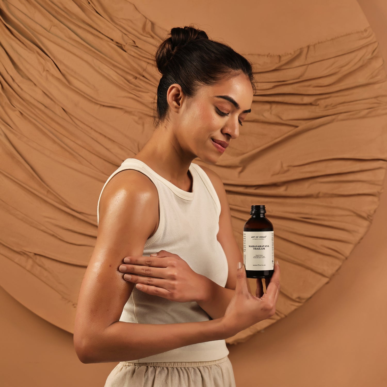 Art of Vedas Mahanarayana Thailam Ayurvedic Herbal Oil - Woman Holding Ayurvedic Joint and Muscle Oil for Pain Relief