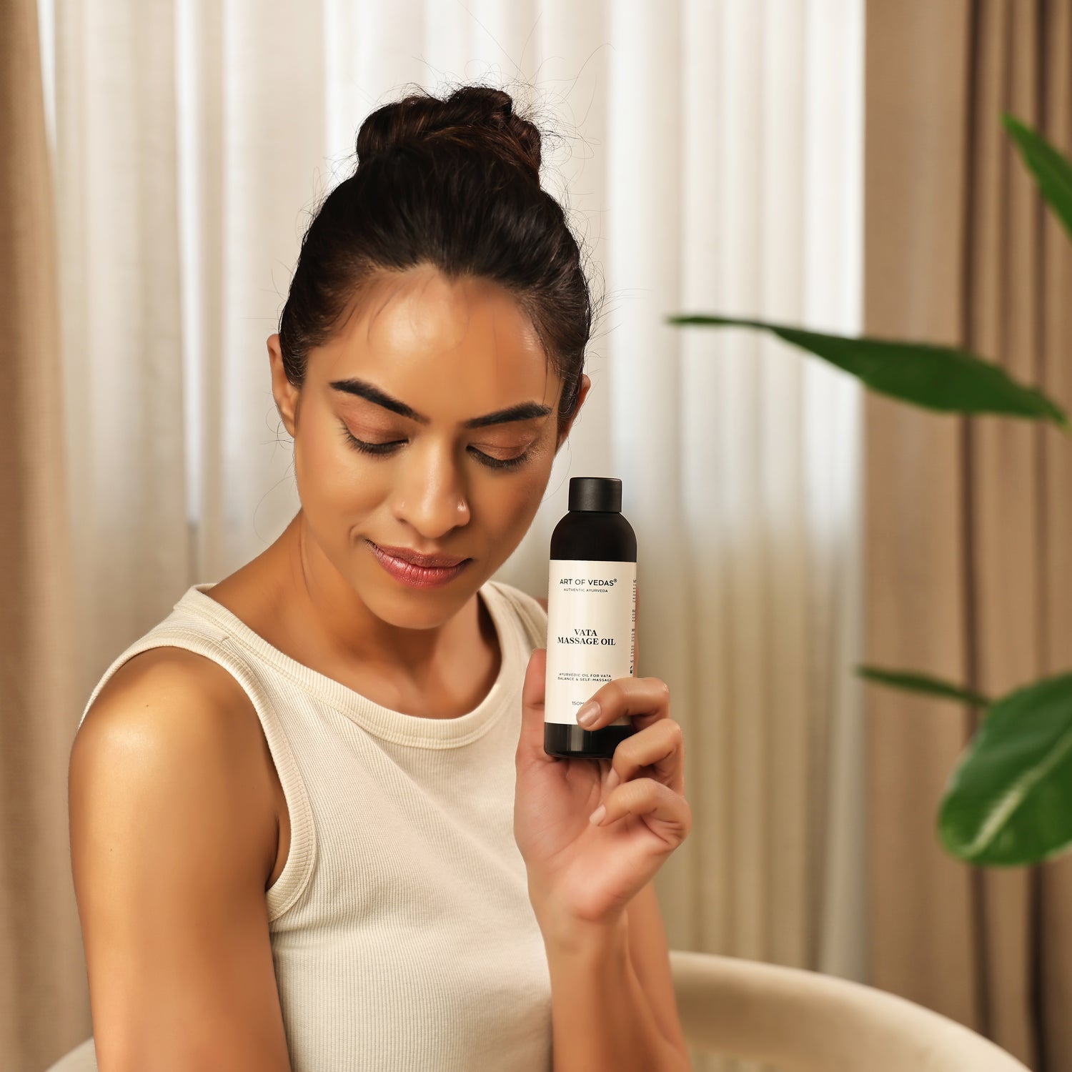 Art of Vedas Vata Massage Oil - Woman Holding Ayurvedic Vata Balancing Oil Bottle for Grounding and Nourishing Abhyanga Massage